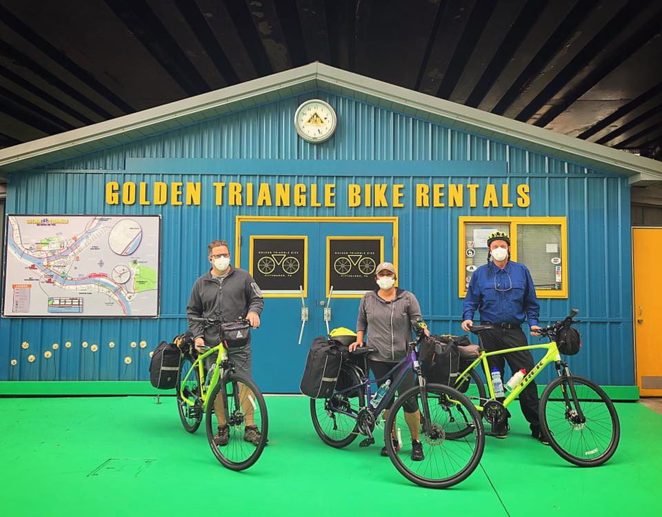 Photo shows three bikers wearing face masks posing in front of Golden Triangle Bike Rentals