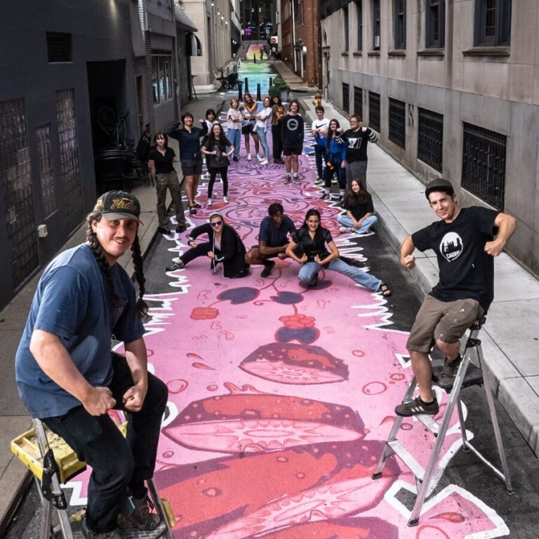 A group of people in the ally showing of the art the made.