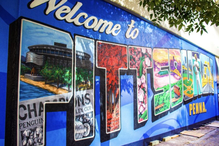 A post cars style graphic painted on a wall that reads: Welcome to Pittsburgh
