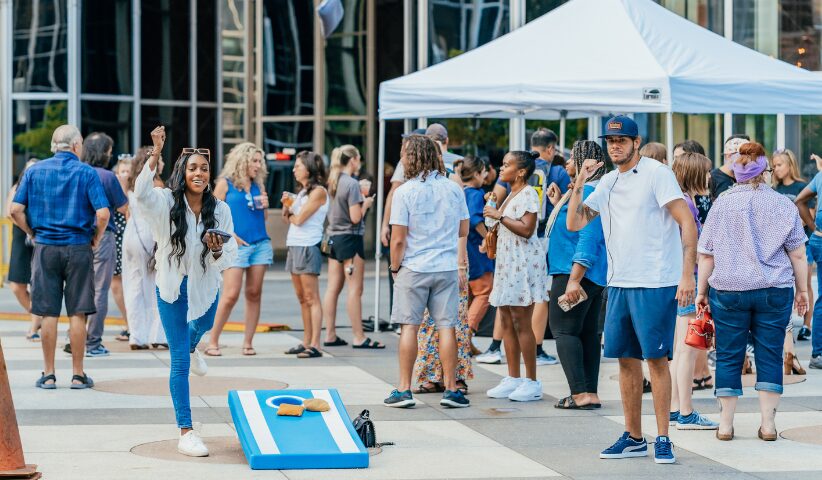 A woman playing corn hole in ppg plaza