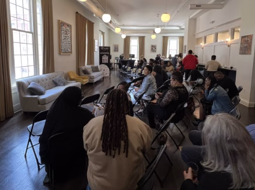 A large group of people sitting in a room.