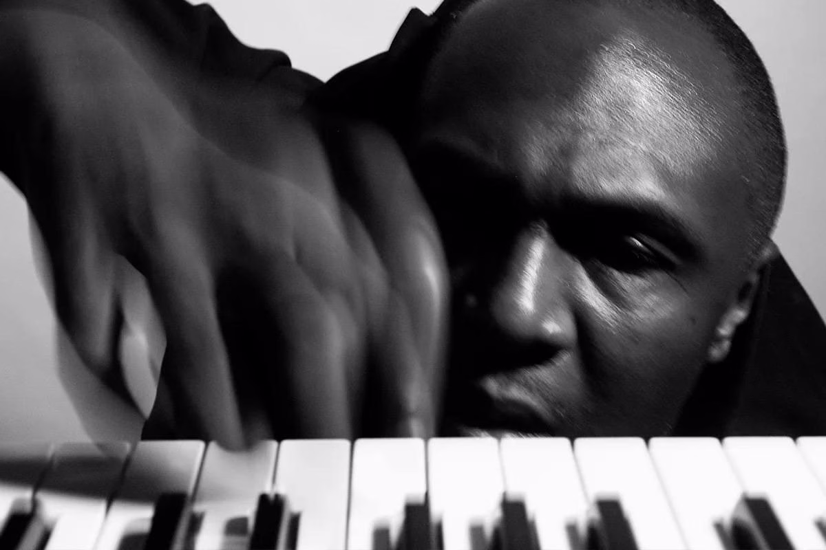 An artist photo of a man in front of a key board for Hprizm: Sound of the City