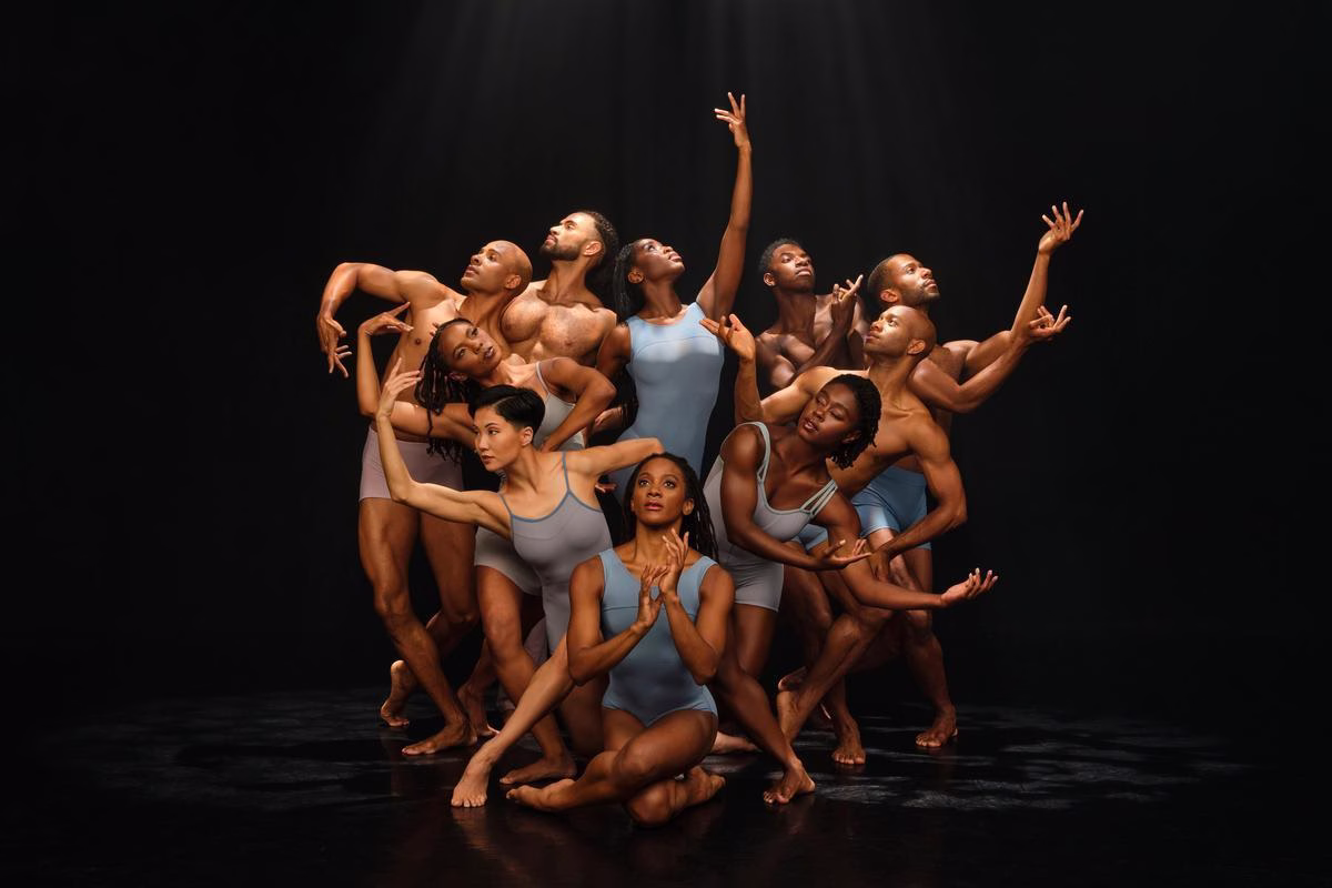 A group of performers huddled closely all expressing different poses