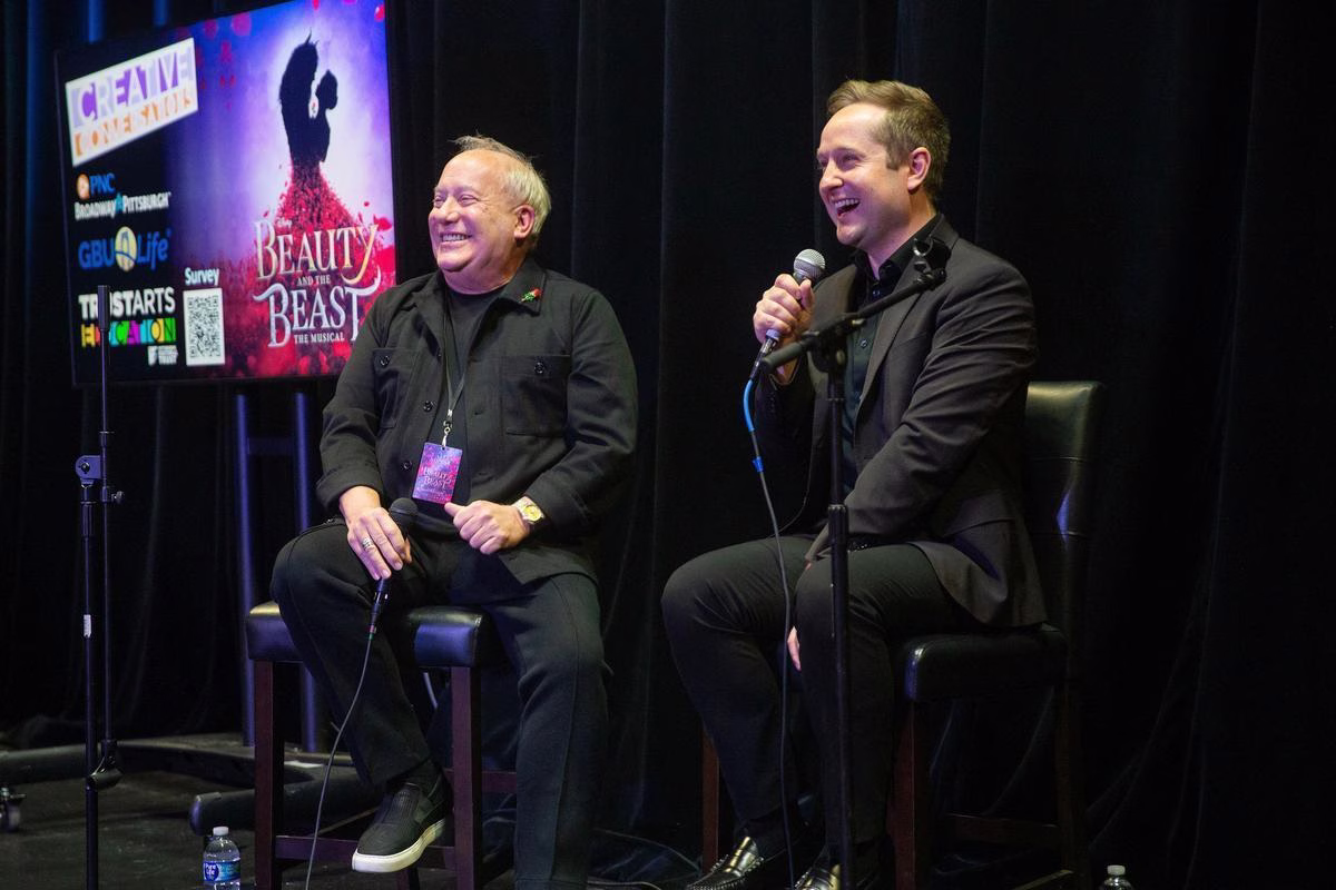 Two men speak on stage for Creative Conversations: The Lion King